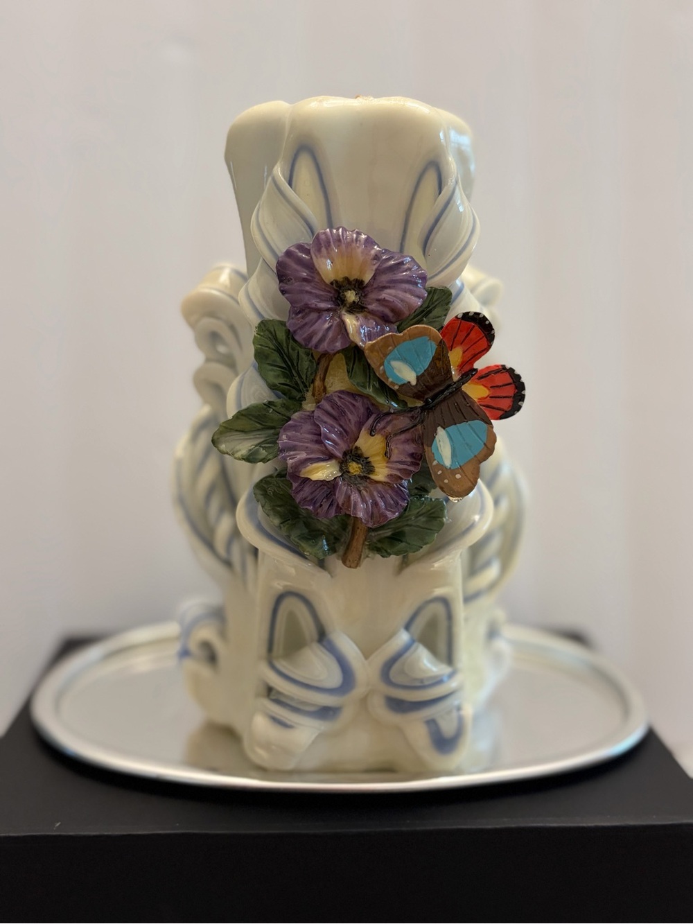 hand-carved wax candle by Melanie H Demmon featuring flora and butterflies